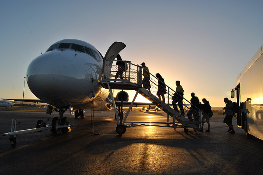 On the airfield image 6 - Passengers walking up stairs to board a plane